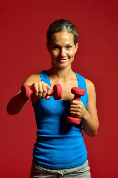 Vacker ung kvinna som tränar i gymmet — Stockfoto