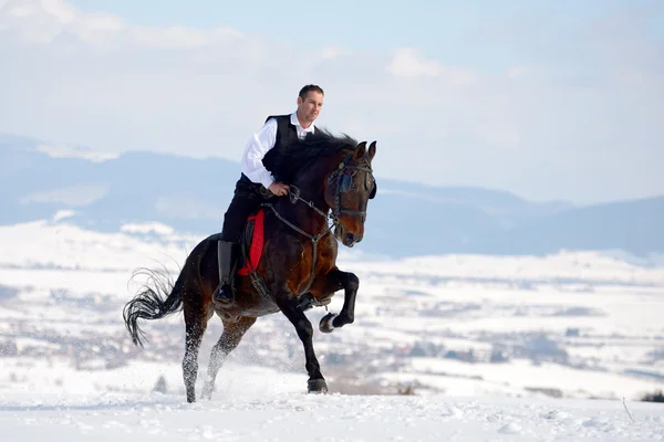 Νεαρός άνδρας ιππασία εξωτερική το χειμώνα年轻人骑着马在冬天室外 — 图库照片