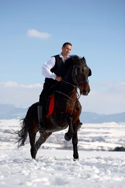 Jeune homme équitation cheval en plein air en hiver — Photo