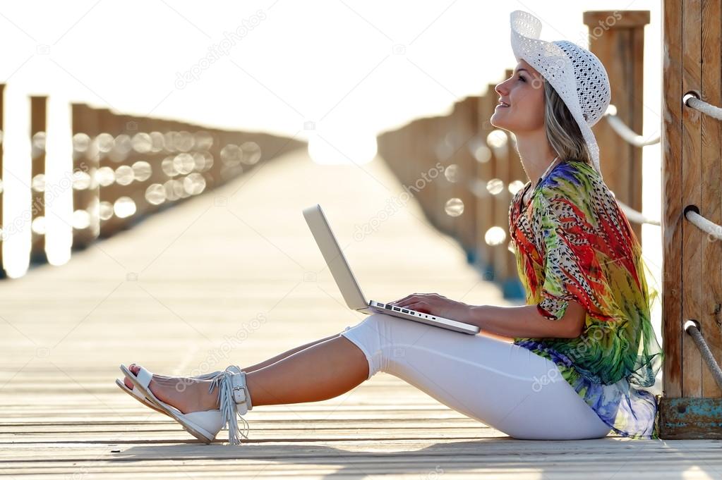 young woman using laptop outdoor in summer