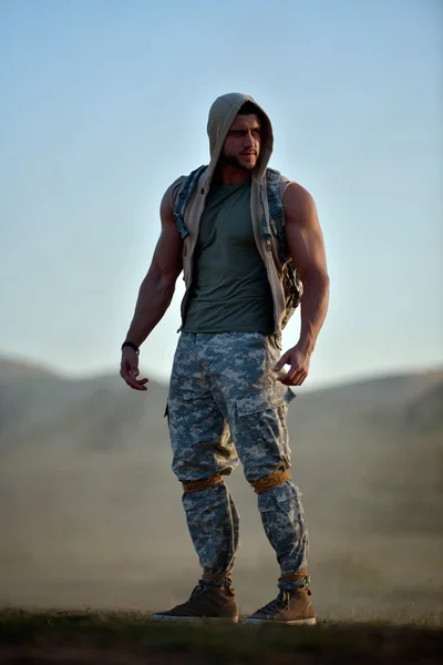 Athletic young man on dusty field — Stock Photo, Image