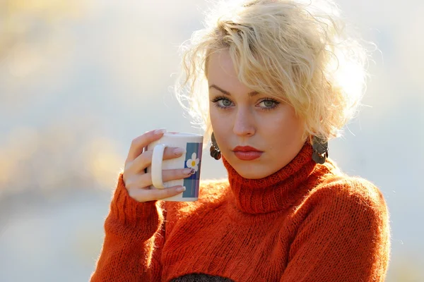 Young woman holding cup of tea outdoor — Stock Photo, Image