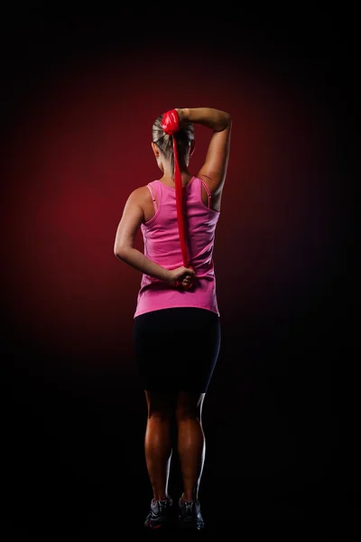 체육관에서 피트 니스 탄성 밴드와 함께 운동 하는 젊은 여자 — 스톡 사진