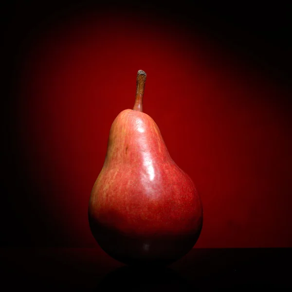 Pera madura aislada sobre fondo rojo — Foto de Stock