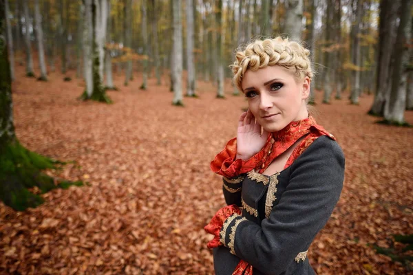 Schöne elegante blonde Frau im herbstlichen Wald — Stockfoto