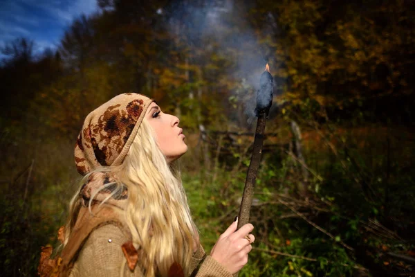 Beautiful young woman outdoor on autumn day holding burning torc — Stock Photo, Image