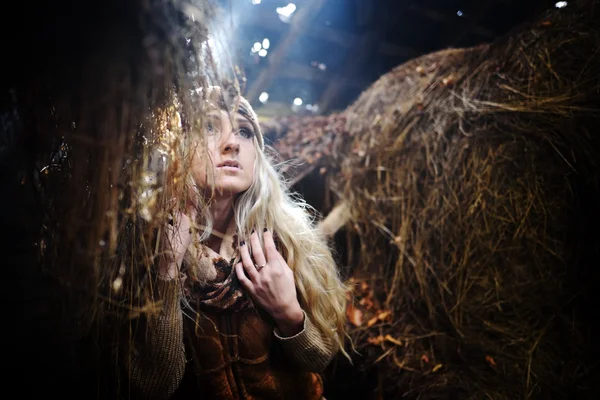 Mooie vrouw ontspannen in stro in de herfst in rokerige, stoffige kamer — Stockfoto