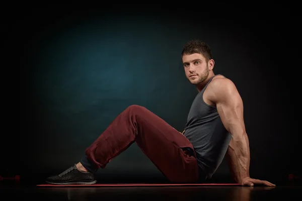 Athletic young man portrait in studio with dark background — Stock Photo, Image