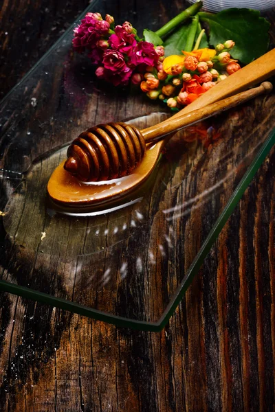 Miel de oro en el plato y flores de colores —  Fotos de Stock