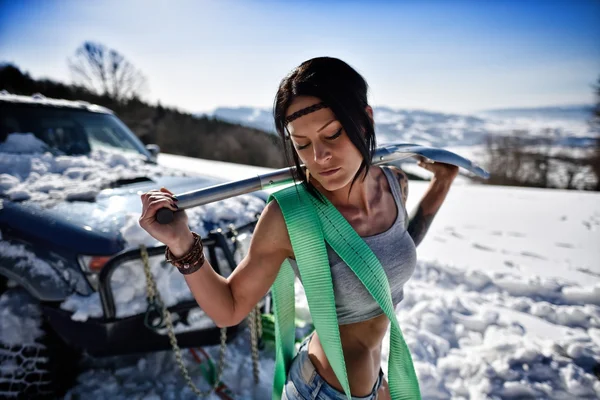 Jovem atlético mulher puxando carro no inverno — Fotografia de Stock