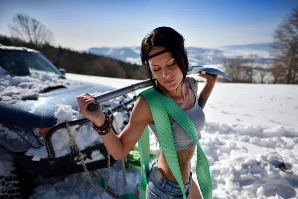 Jeune femme athlétique tirant la voiture en hiver — Photo