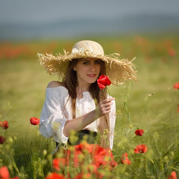 Jonge mooie vrouw op granen veld met papavers in de zomer — Stockfoto