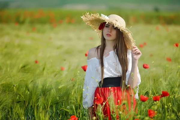 Mladá krásná žena na obilné pole s máky v létě — Stock fotografie