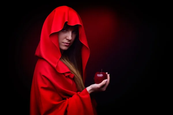 Schöne Frau mit rotem Mantel und Apfel in der Hand - Studioaufnahme — Stockfoto