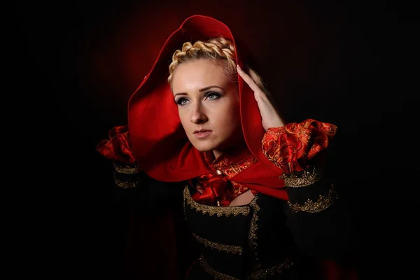 Beautiful woman with red cloak in studio — Stock Photo, Image