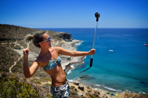 Jonge vrouw op het strand in de zomer met behulp van gopro — Stockfoto