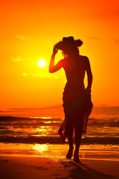 Jonge vrouw silhouet op het strand in de zomer zonsondergang licht — Stockfoto