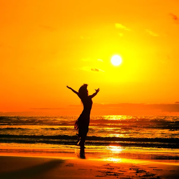 Jonge vrouw silhouet op het strand in de zomer zonsondergang licht — Stockfoto