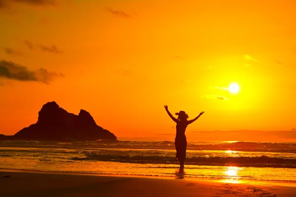 Силуэт молодой женщины на пляже в летнем закате — стоковое фото