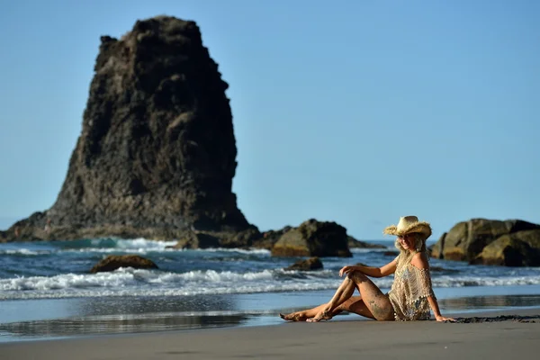 Young woman sitting on the beach in summer vacation — Stock Photo, Image