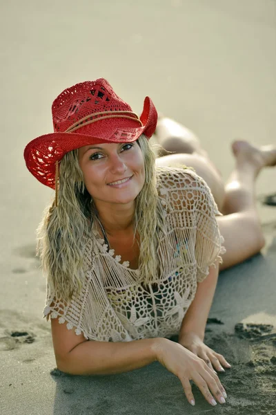 Młoda kobieta siedząca na plaży — Zdjęcie stockowe