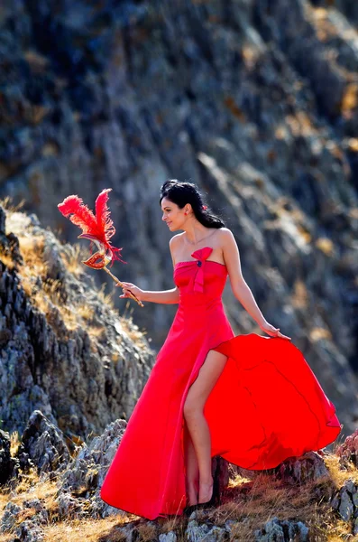 Young woman wearing long red dress and mask — Stock Photo, Image