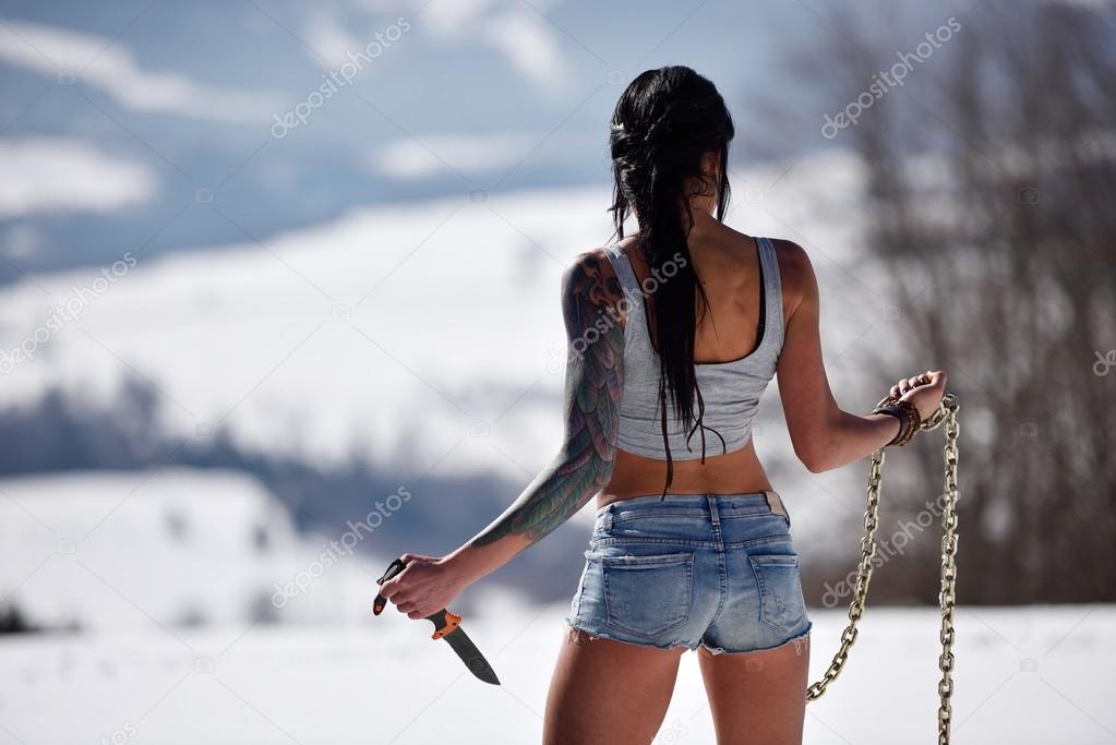 Attractive sensual woman in shorts holding knife