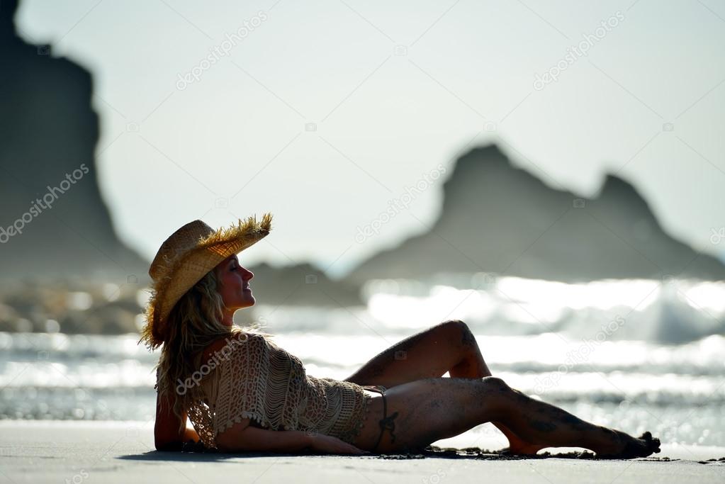 young woman sitting on the beach in summer vacation