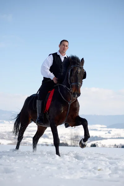 Young man riding horse outdoor in winter — Stock Photo, Image