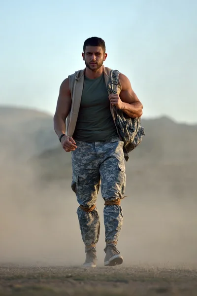 Athletic young man on dusty field — Stock Photo, Image