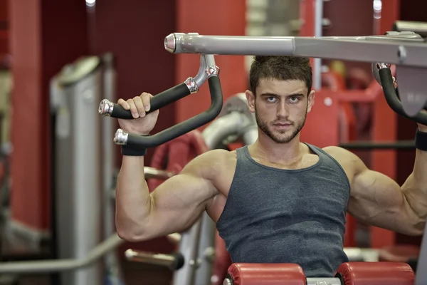 Ung vacker man tränar i gymmet — Stockfoto