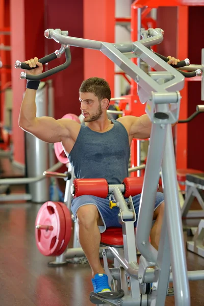 Junger schöner Mann trainiert in der Turnhalle — Stockfoto