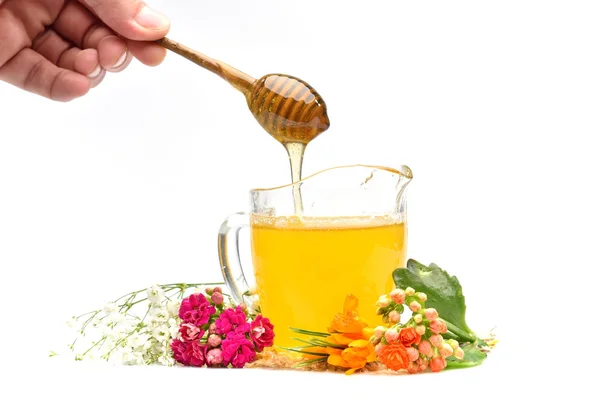 Golden honey and colorful flowers — Stock Photo, Image