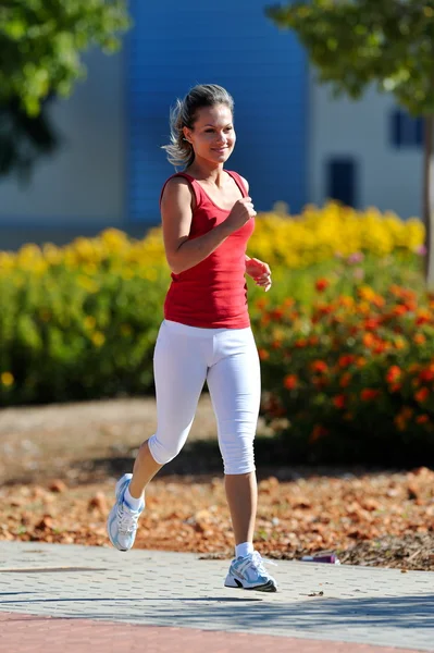 Giovane donna che corre nel parco — Foto Stock