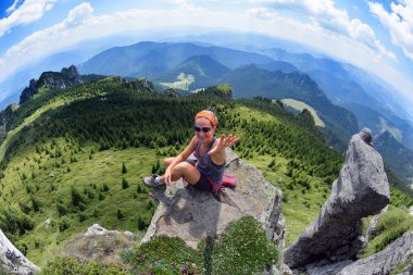 Kayanın üzerinde oturan genç mutlu kadın