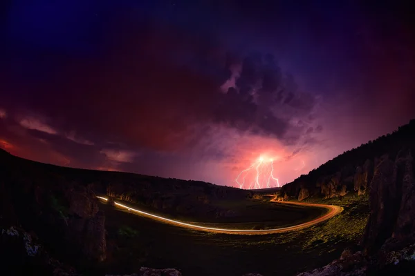 Iluminação e tempestade sobre colinas durante a noite — Fotografia de Stock