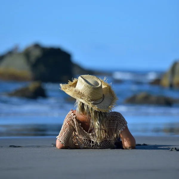 Young woman sitting on the beach — Stock Photo, Image