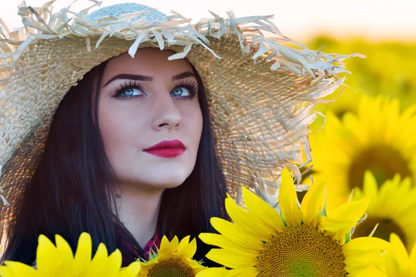 Unga vackra kvinnan på solros fält — Stockfoto