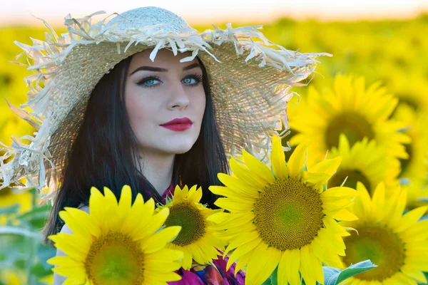 Unga vackra kvinnan på solros fält — Stockfoto