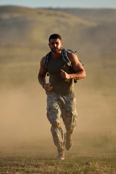 Athletic young man on dusty field — Stock Photo, Image