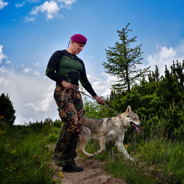 Joven sosteniendo Wolfdog checo — Foto de Stock