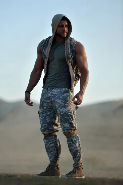 Athletic young man on dusty field — Stock Photo, Image