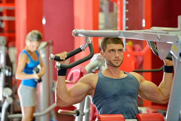 Jeune homme beau exercice dans la salle de gym — Photo