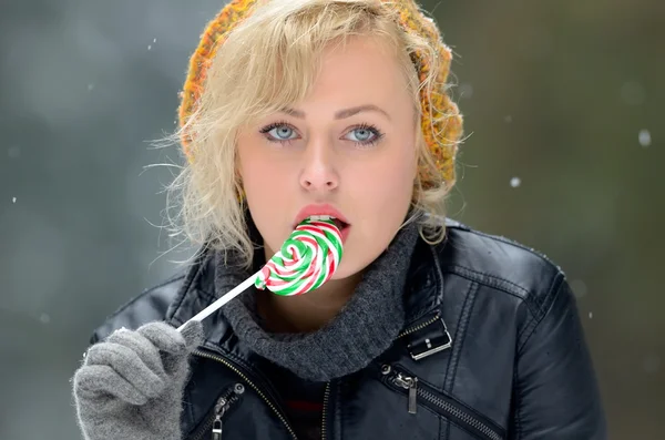 Vacker kvinna äta lollipop utomhus — Stockfoto