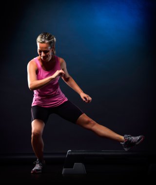 Spor salonunda egzersiz yapan genç bir kadın.