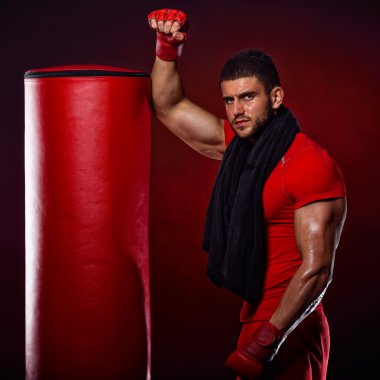 young man standing by  boxing bag clipart