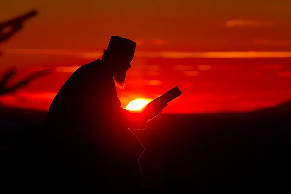 Siluetă de lectură preot în lumina apusului de soare, România, Ceahl — Fotografie, imagine de stoc