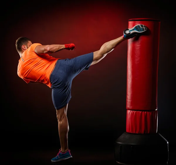 Jovem homem exercitando saco de boxe — Fotografia de Stock