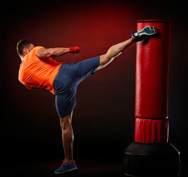 Joven hombre ejercitando bolsa de boxeo — Foto de Stock