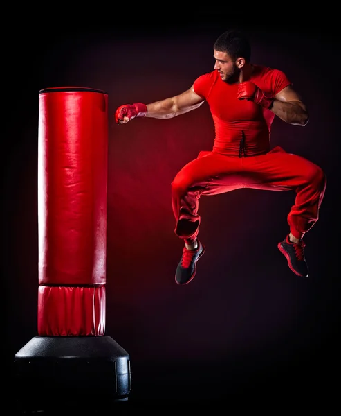 Young man exercising bag boxing in studio — Stock Photo, Image